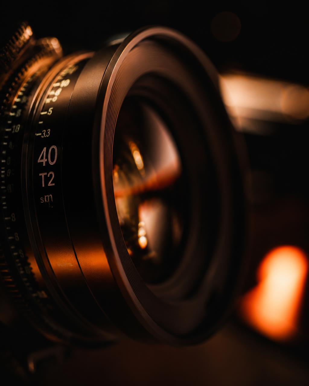 Close-up of a cinema lens with warm amber lighting